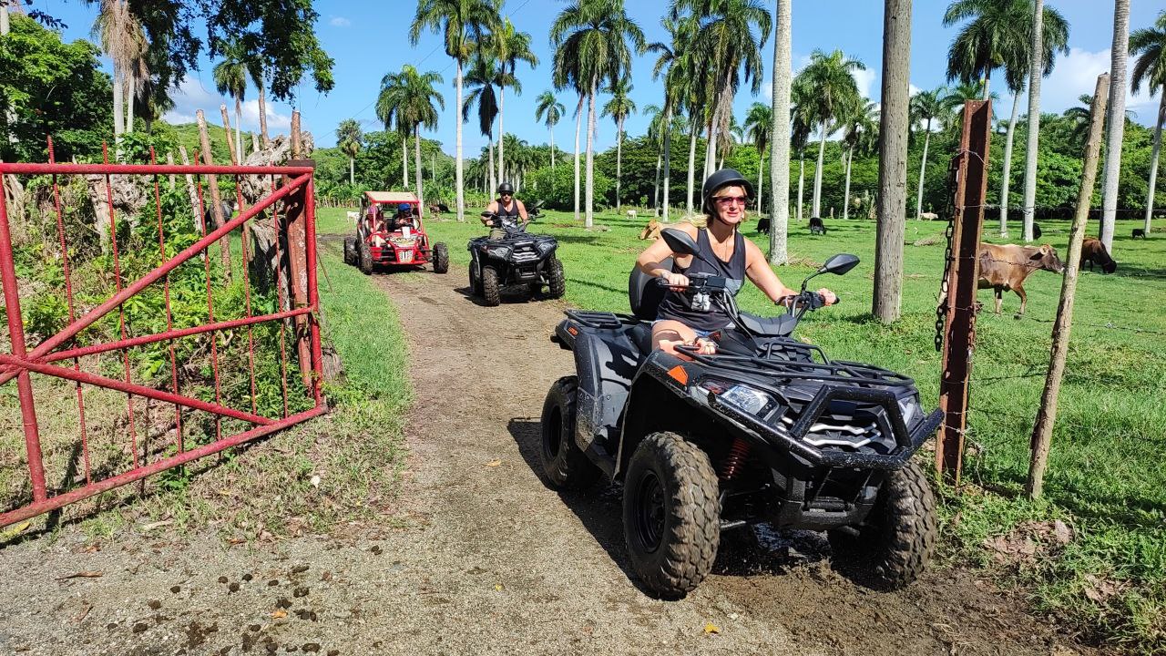 Grupo de turistas en ATV y buggy pasando por la entrada del rancho en Puerto Plata