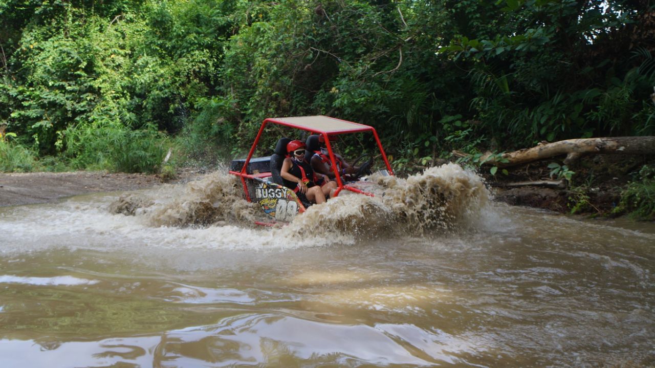 Buggy cruzando un río lodoso durante una ruta extrema en Puerto Plata