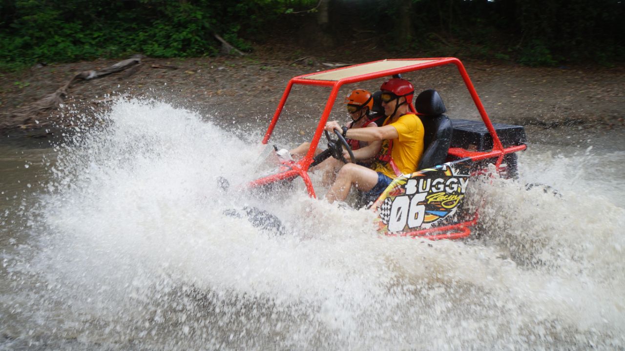 Buggy rojo 06 con agua salpicando a toda velocidad en riachuelo de Maimón