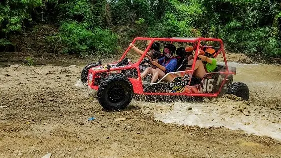 Grupo disfrutando un buggy familiar cubierto de barro tras el recorrido